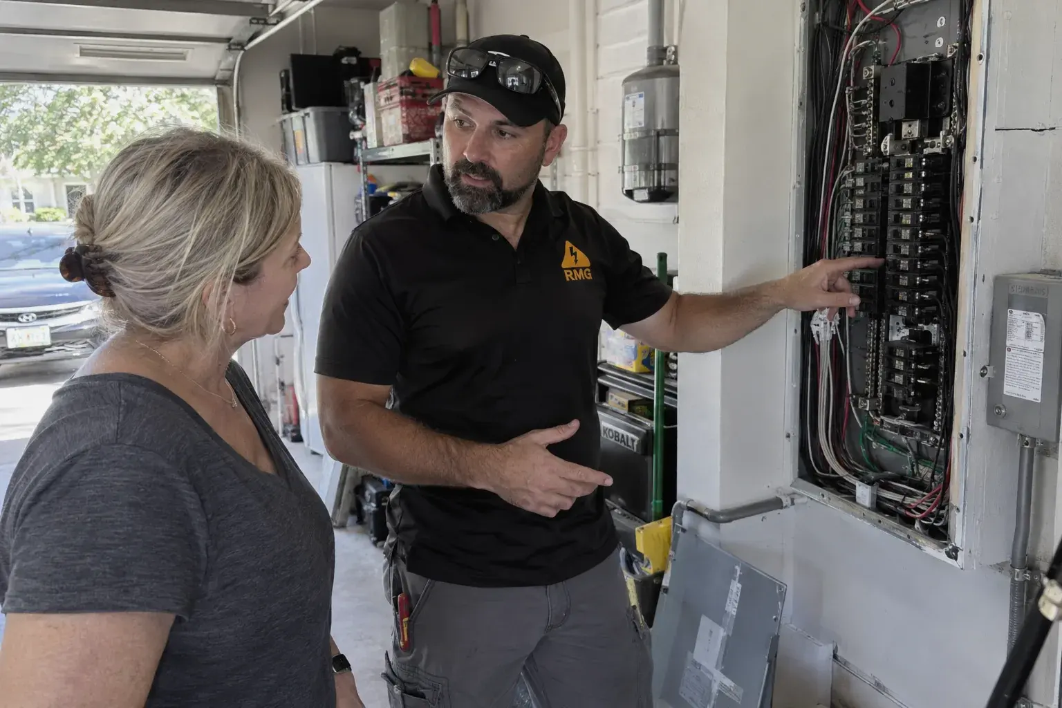 Electrician explaining the panel work to a homeowner in her garage
